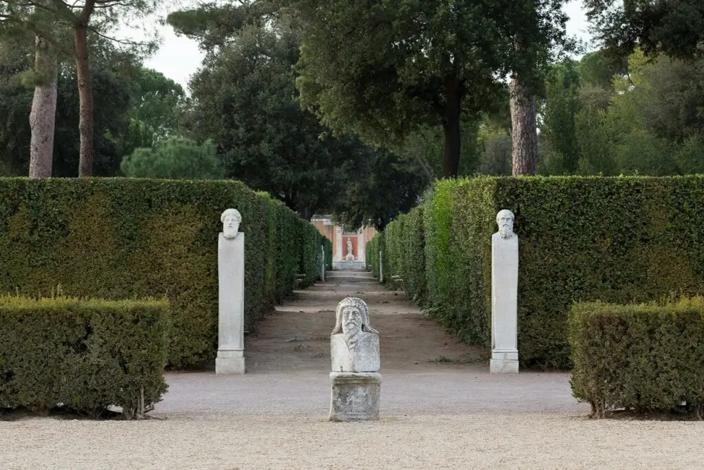 Garden path with stone bust statues and hedges