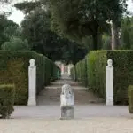 Garden path with stone bust statues and hedges