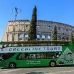 Green tour bus near the Colosseum in Rome.